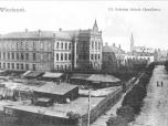 (37/48): Włocławek. Ul. Szkolna Szkoła Handlowa.<br>fot. Sztejner, przed 1913 r.<br>Widok Szkoły Handlowej (ob. Liceum Ziemi Kujawskiej) od ulicy Szkolnej (ob. Mickiewicza) od ulicy Wspólnej (ob. Kilińskiego). Perspektywa ulicy Szkolnej zamknięta ulicą Ogrodową (ob. Słowackiego). W tle wieże i korpus bazyliki katedralnej. Na pierwszym planie dziedziniec fabryki D. Reich i S-ka przy ulicy Wspólnej 16.